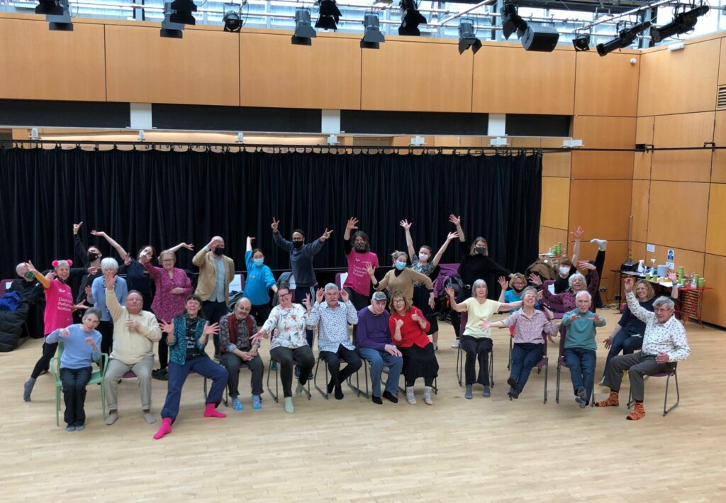 The picture shows participants in a Dance for Parkinson's class. They are facing the camera, with what appears to be some doing jazz hands. 